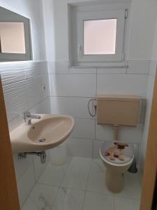 a white bathroom with a toilet and a sink at Shalom 