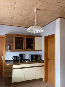 a kitchen with a microwave and a chandelier at Shalom 