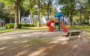 - un parc avec une aire de jeux dotée d'un toboggan et d'un banc dans l'établissement Familie Vakantiehuisje F108 - 4p - Hengelhoef - Houthalen-Helchteren, à Aan de Wolfsberg