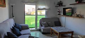 een woonkamer met een bank, een tafel en een raam bij Apartamento Luminoso el Morche in Morche