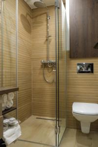 a bathroom with a shower and a toilet at Harmonija Resort - Harmonia Palace in Kopaonik