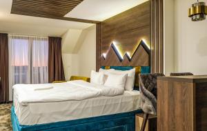 a hotel room with a bed with a wooden headboard at Harmonija Resort - Harmonia Palace in Kopaonik