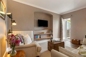 a living room with a couch and a tv at Caldey Island View - Sea Views and Log Burner in Penally