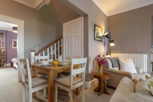 a living room with a table and chairs and a couch at Caldey Island View - Sea Views and Log Burner in Penally +13 photos