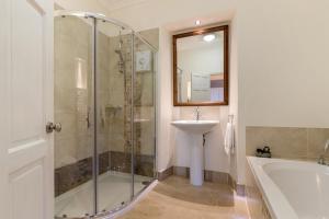 a bathroom with a shower and a sink and a tub at Caldey Island View - Sea Views and Log Burner in Penally