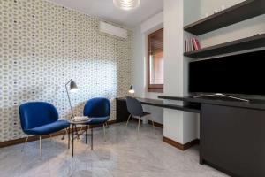 a living room with a television and blue chairs at Silenzioso Appartamento Repubblica Home in Milan