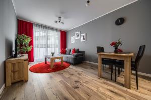 ein Wohnzimmer mit einem Sofa und einem Tisch in der Unterkunft Central Park Red Apartment in Breslau