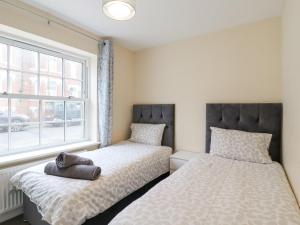 sypialnia z 2 łóżkami i oknem w obiekcie 21A Saville Road w mieście Walton-on-the-Naze