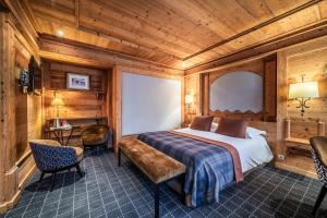 een slaapkamer met een bed en een tafel en stoelen bij Hotel Le Samoyede in Morzine