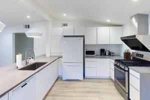 a white kitchen with white cabinets and a refrigerator at Cupertino 3br w patio backyard nr restaurants SFO-1636 in Cupertino