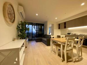 een keuken en een woonkamer met een tafel en stoelen bij Peaceful & Relaxing City Escape @ Rundle Mall in Adelaide