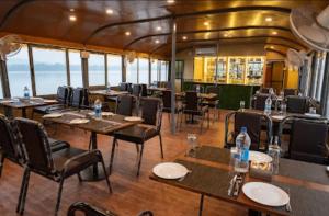 um restaurante num barco com mesas e cadeiras em Seascape Floating Paradise em