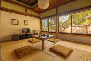 een woonkamer met een tafel en een televisie bij 宿坊 大泰寺 Temple Hotel Daitai-ji in Shimosato