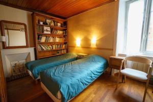 a bedroom with a bed and a book shelf at Parfum dEmbruns in Hirel