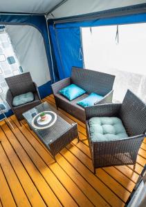 a deck of a boat with two chairs and a table at Maszoperia Sun4hel in Jastarnia