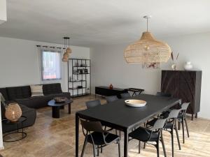 ein Wohnzimmer mit einem schwarzen Tisch und Stühlen in der Unterkunft Villa Hélène in Malaucène