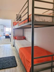 ポルティマンにあるEstúdio Praia da Rocha Peachyのベッドルーム1室(二段ベッド2組付)、リビングルームが備わります。