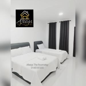 two beds in a room with a sign that reads keep the frequency at Afeeya The Roomstay in Kuala Terengganu