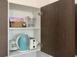 uma cozinha com um armário com alguns electrodomésticos em Lovely 2-BR service apartment with pool (melur @ troikaKB) em Kota Bharu