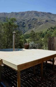 a wooden table with a view of a mountain at Luxury cabin in the Swellendam valley, W.C. in Swellendam