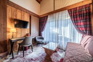 a hotel room with a desk and a couch at Hotel Le Samoyede in Morzine