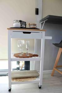 a white cart with two wine glasses on it at Luxury cabin in the Swellendam valley, W.C. in Swellendam