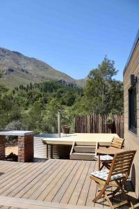 a wooden deck with two chairs and a table at Luxury cabin in the Swellendam valley, W.C. in Swellendam