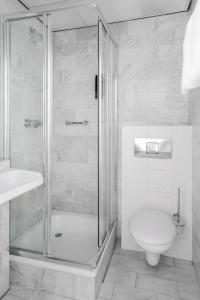 a bathroom with a shower and a toilet and a sink at Hotel City Garden Amsterdam in Amsterdam