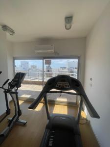 un gimnasio con 2 cintas de correr en una habitación con ventana en Loft con piscina en Punta Carretas, en Montevideo