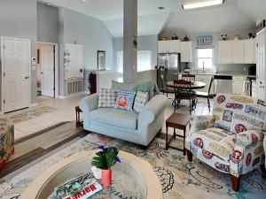 a living room with a couch and chairs and a kitchen at Beach Place in Port Aransas