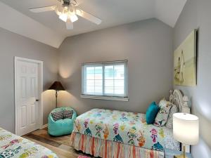 a bedroom with two beds and a ceiling fan at Beach Place in Port Aransas +21 photos