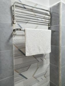 a towel rack in a bathroom with a white towel at Khomes cosy studio in Nairobi