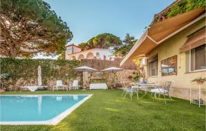 um quintal com piscina e cadeiras e uma casa em Beautiful Home In Arenys De Mar With Wi-fi em Arenys de Mar