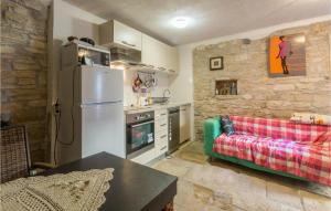 a kitchen with a refrigerator and a couch in a room at 2 Bedroom Stunning Home In Bale in Bale