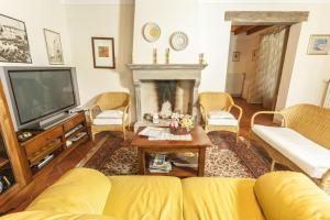 a living room with a yellow couch and a fireplace at Casa Limonaia in Arezzo