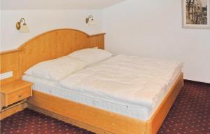 łóżko w sypialni z drewnianym zagłówkiem w obiekcie Gemuetliche Ferienwohnung w mieście Flachau
