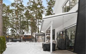 un edificio blanco con nieve en el suelo en Nice Home In Vrmd With Kitchen, en Värmdö