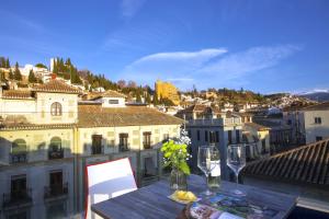 un tavolo con bicchieri da vino in cima a un balcone di Casual Ilbira Granada a Granada