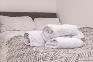 a pile of towels sitting on top of a bed at 1-BR Gem in Sheffield - Easy City Centre Access in Sheffield