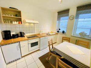 una cocina con electrodomésticos blancos y una mesa. en Landhaus Immenbarg, Warnow, en Warnemünde