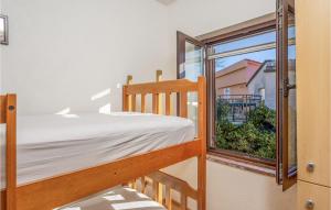 a bedroom with a bunk bed and a window at Cozy Home In Cesarica With Kitchen in Cesarica