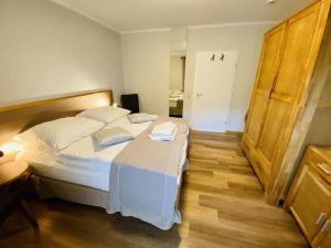 1 dormitorio con 1 cama grande con sábanas y almohadas blancas en Landhaus Immenbarg, Sonne, en Warnemünde