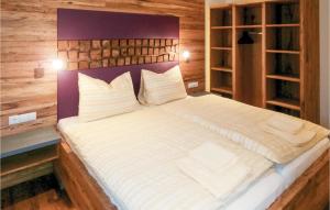 a large bed in a room with wooden walls at 2 Bedroom Gorgeous Apartment In Wagrain in Wagrain