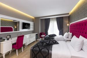 イスタンブールにあるDencity Hotels & Spaの赤いヘッドボード付きの大きなベッドが備わるホテルルームです。