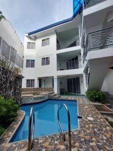 una piscina di fronte a un edificio di El Puerto Boracay Shore a Boracay