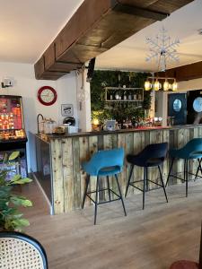 eine Bar mit vier blauen Stühlen in einem Zimmer in der Unterkunft The Crown Lodge & Restaurant in Dogdyke