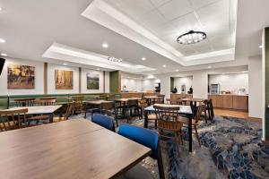 a dining room with wooden tables and chairs at Fairfield by Marriott Chesapeake in Chesapeake