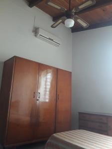 una camera da letto con un armadio in legno e un ventilatore a soffitto di Alquiler Corral de Bustos a Corral de Bustos