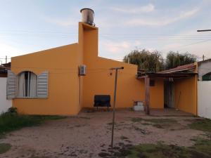 una casa gialla con una sedia davanti di Alquiler Corral de Bustos a Corral de Bustos