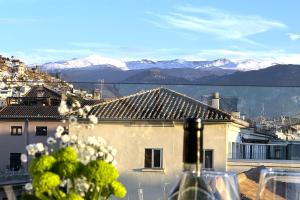 una botella de vino en una mesa con vistas a las montañas en Casual Ilbira Granada, en Granada